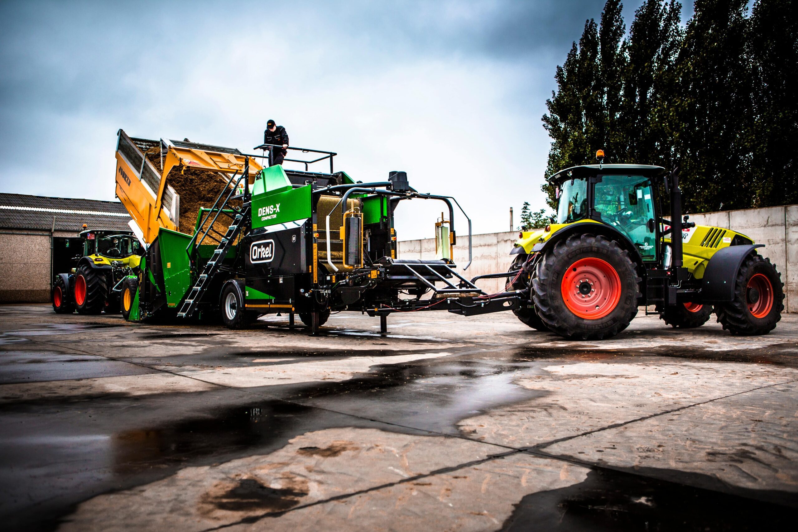 A Dens-X compactor between a tipper truck and a tractor.