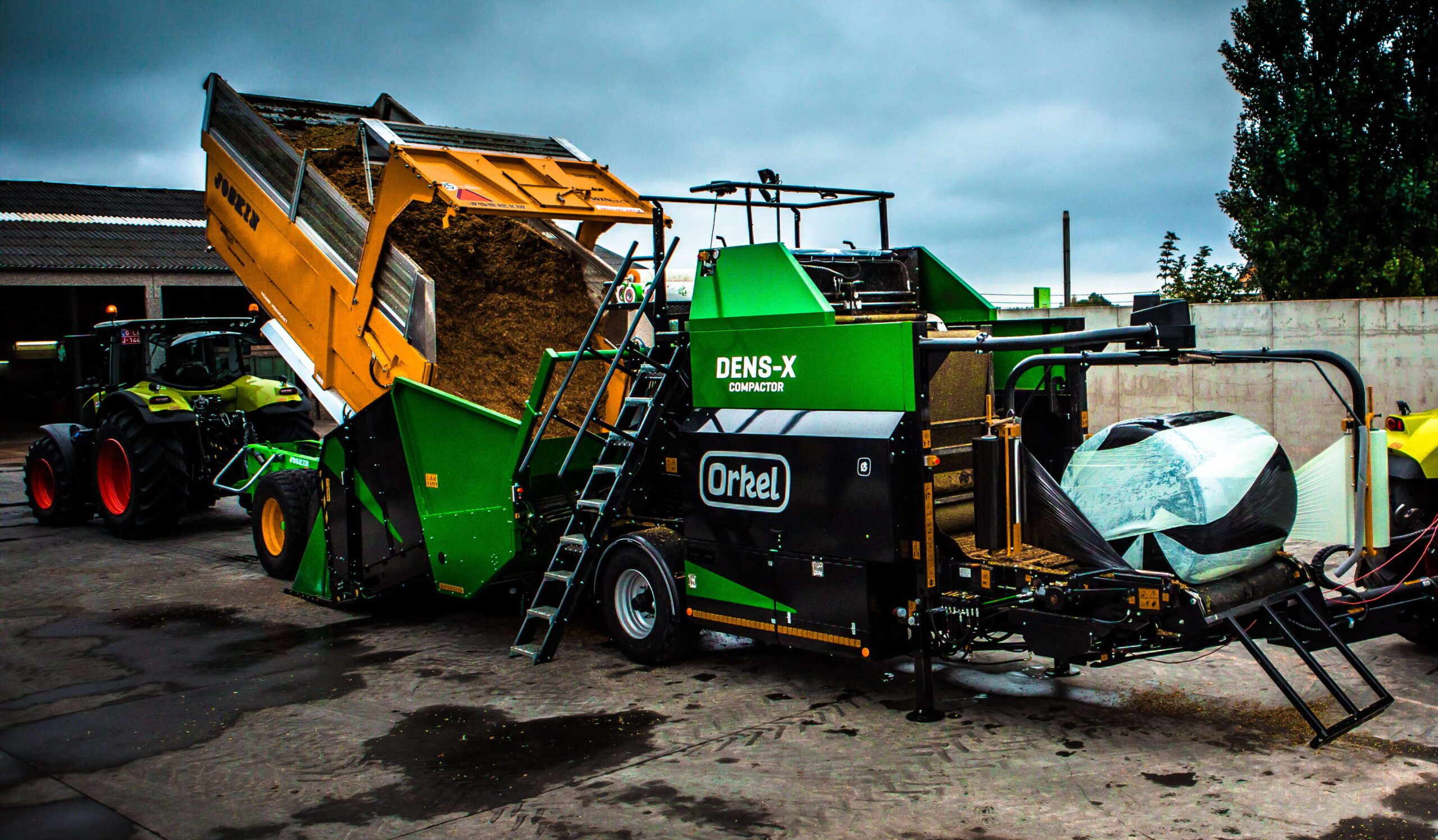 A tipper truck loading bulk material onto the feeding table of a Dens-X compactor