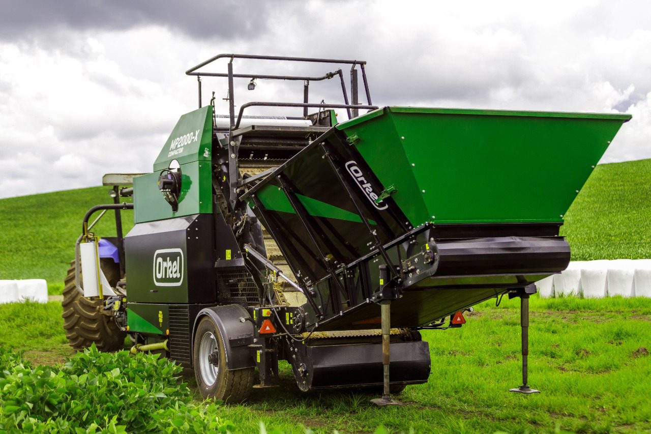 An MP2000-X compactor in a green field with its feeding table facing the camera.