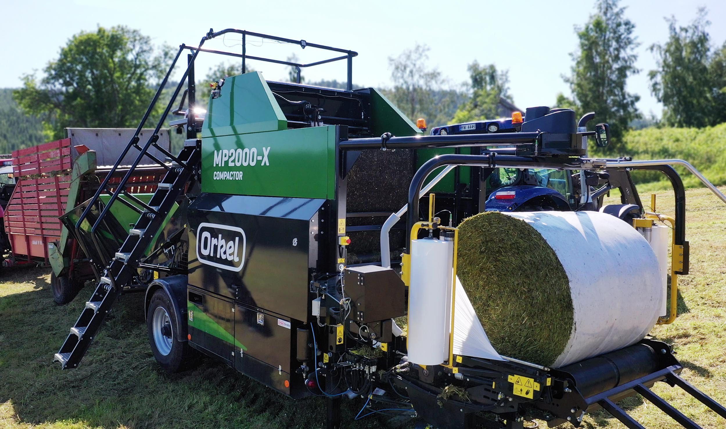 An MP2000-X in operation, with a half-wrapped grass bale on its wrapping table.