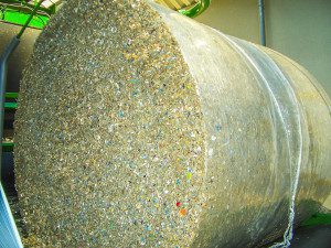 A imagem mostra o enfardamento de resíduos com Orkel, um fardo de resíduos está a ser envolto em plástico.