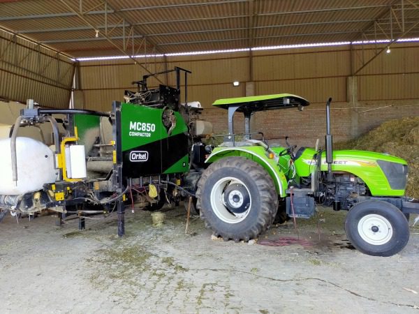Traktor, der während des Ballenpressens an einen Orkel MC850 Kompaktor angeschlossen ist