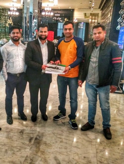 Vier männliche Futterproduzenten in einer Hotellobby halten eine Orkel-Broschüre