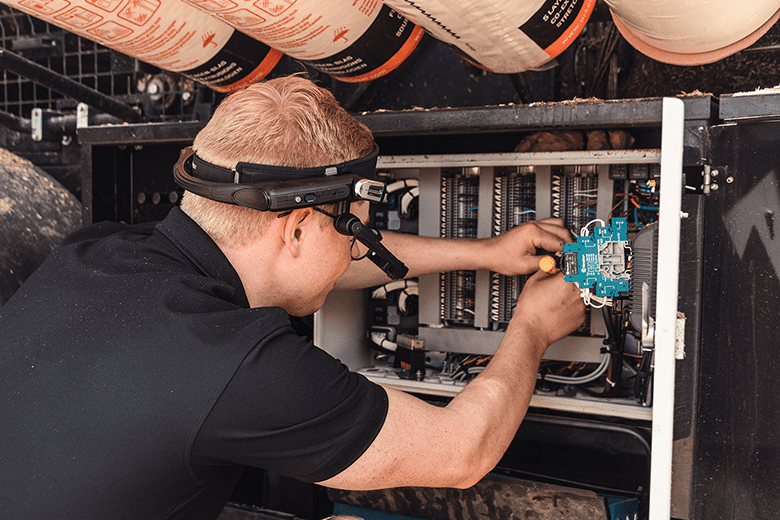 A man wearing smartwear while working in a electrical cabinet executing customer service
