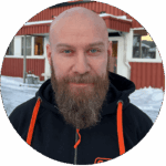 Closeup portrait of a man standing in front of a red building