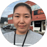 Portrait of a woman standing in front of a red building
