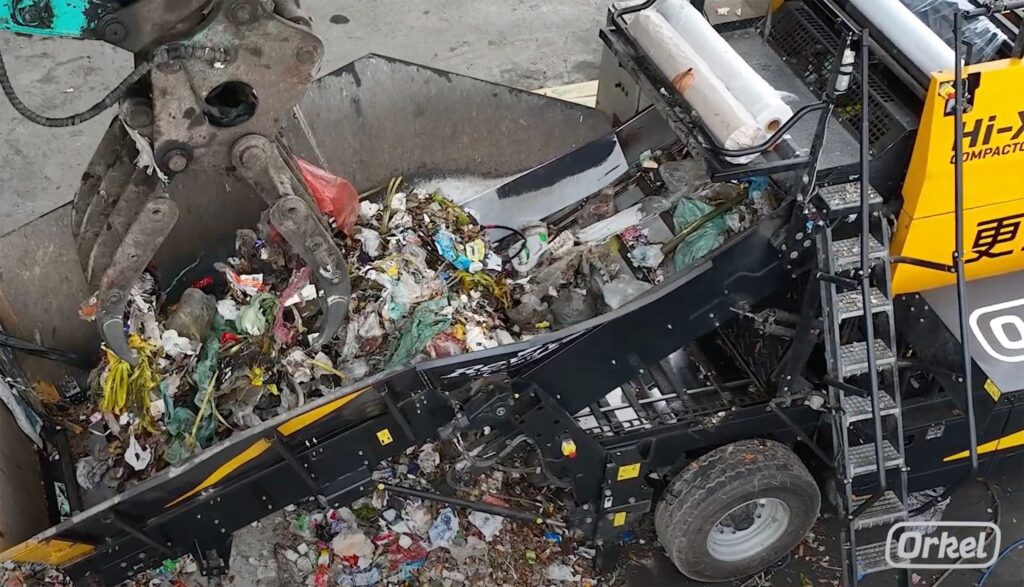 Gros plan d'un tapis roulant rempli de déchets ménagers.