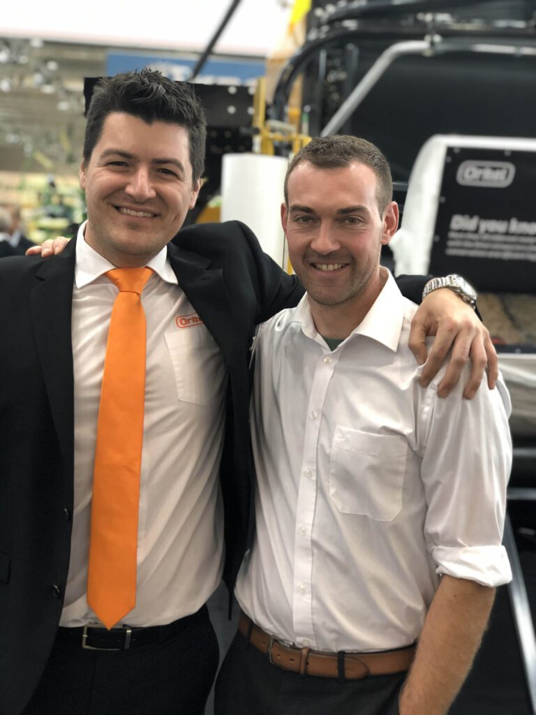 Two guys posing together at a agricultural trade show